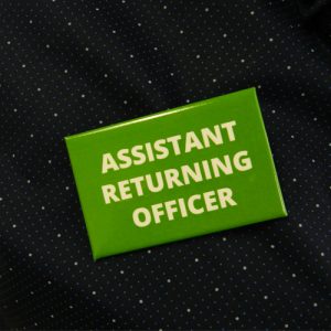 Assistant Returning Officer Badge printed in two colours on aluminum with safety pin back to quickly identify your team members on voting day.