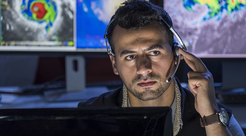 Meteorologist monitoring storms on his computer screens