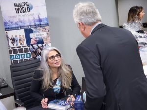 Diane Kalen-Sukra, author of Save Your City, signs copies of her book for delegates at the 2019 OMAA Fall Workshop.