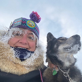 Woman in winter clothing with dog in cold weather.